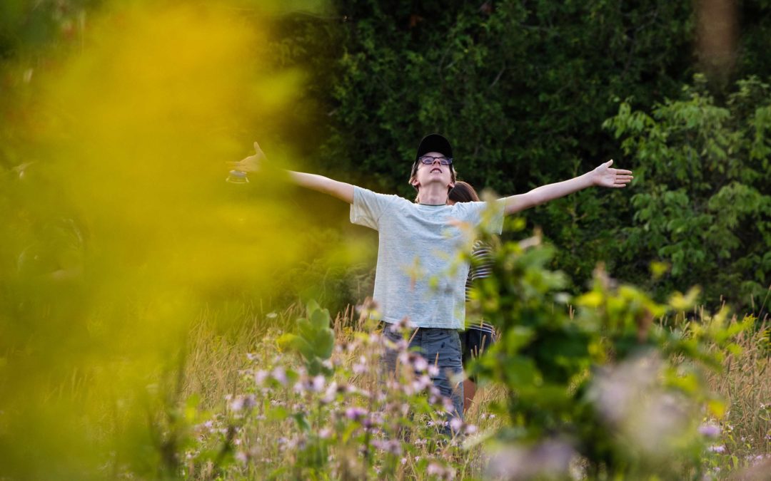 Boy in a field with arms outstretched