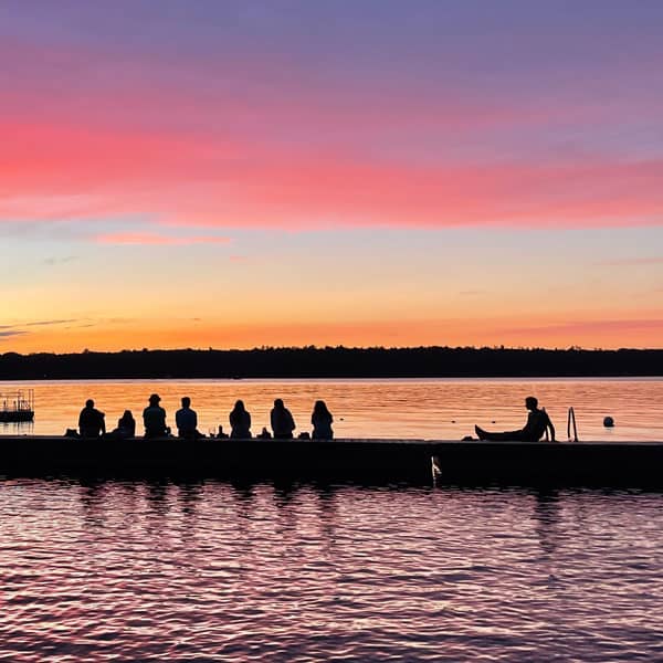 Kids sitting on dock at sunset