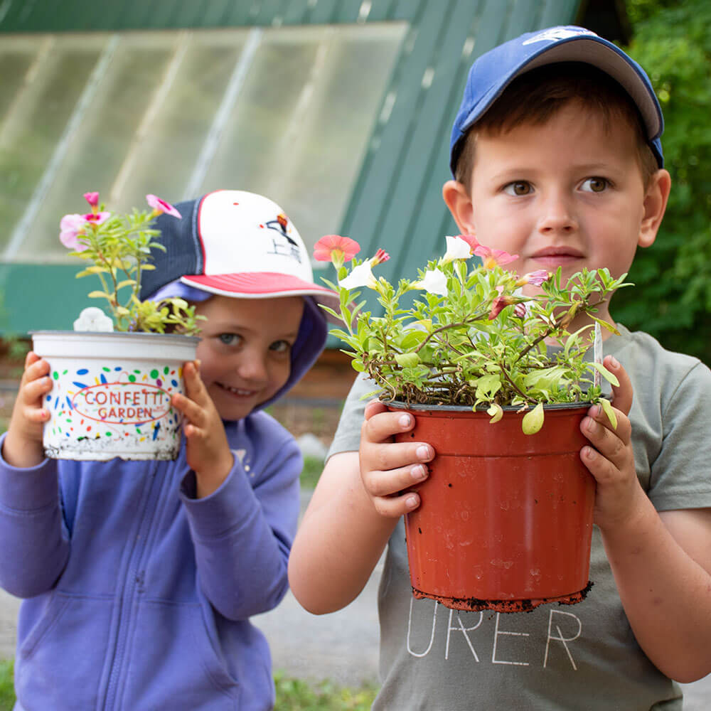 Two young kids holding flower pots
